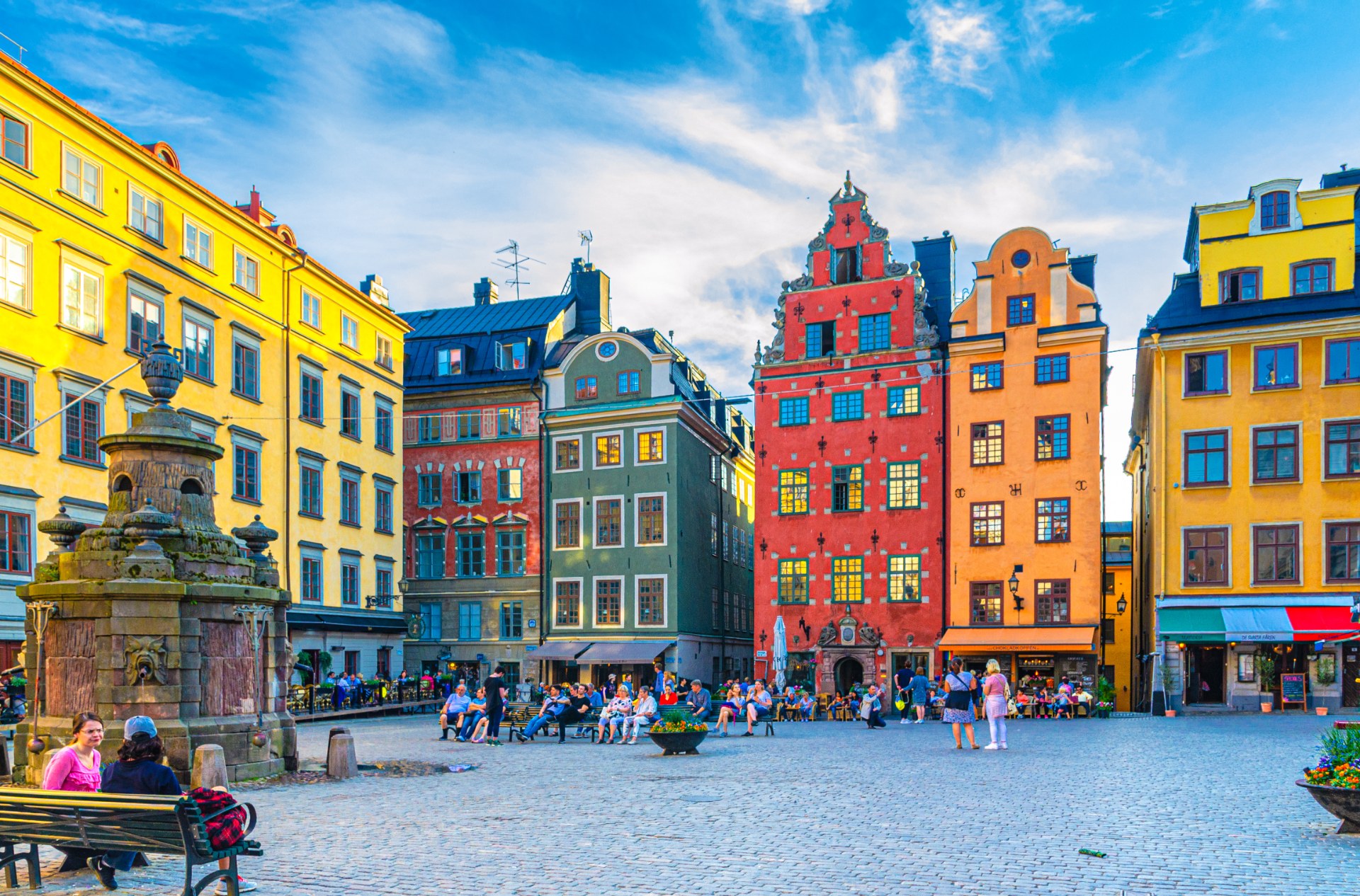 Touristen und Passanten auf dem Stortorget in Stockholm zwischen bunten Bürgerhäusern